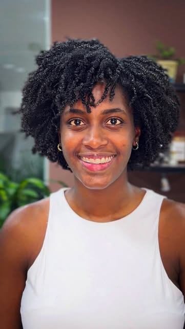 Clienta sonriente con afro corto definido